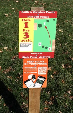 This sign marks the first hole of the new disc golf course at Rice Park. Members of the Christner family designed the signs and ordered them through an online company. The lower sign shows a disc golf phone app users can use to keep store and get details of the course, as well as other courses around the city, state and world.